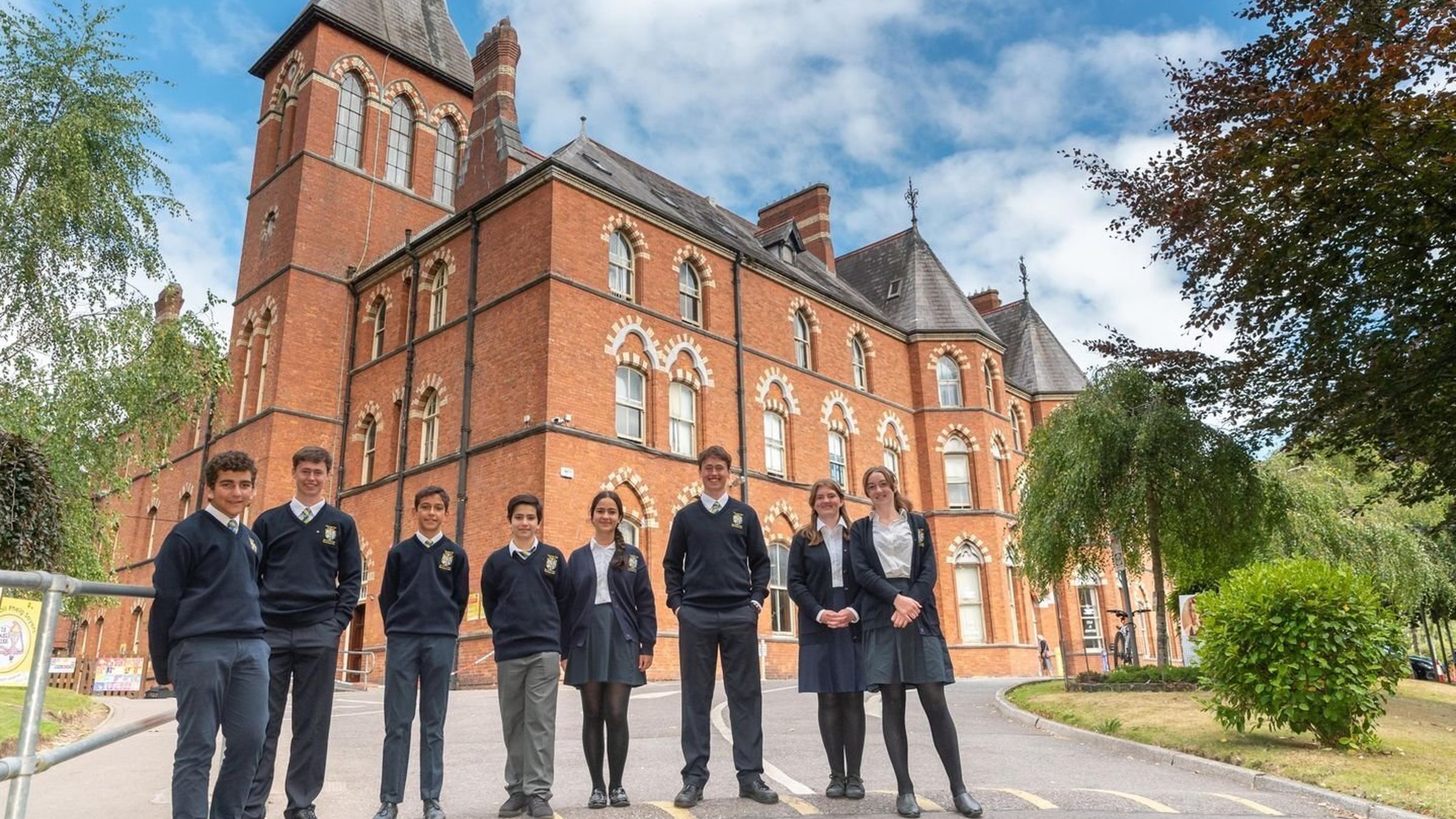 A group of kids smiling in front of a school in Ireland